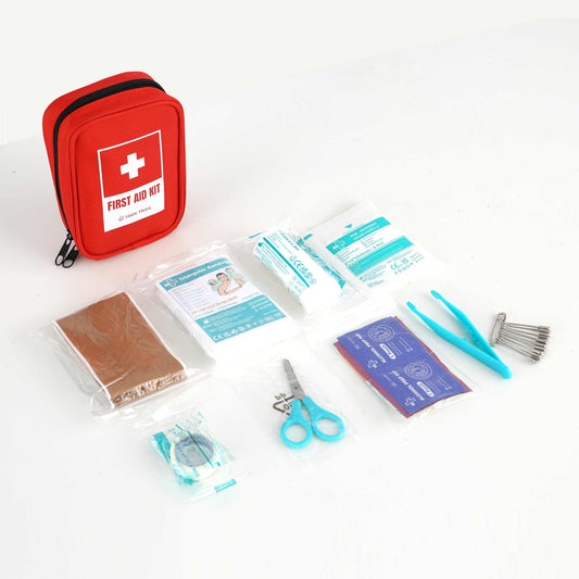 førstehjælpssæt med 31 dele inklusive plaster, renseservietter, gaze, bandager, saks, pincet og sikkerhedsnåle i kompakt rød taske