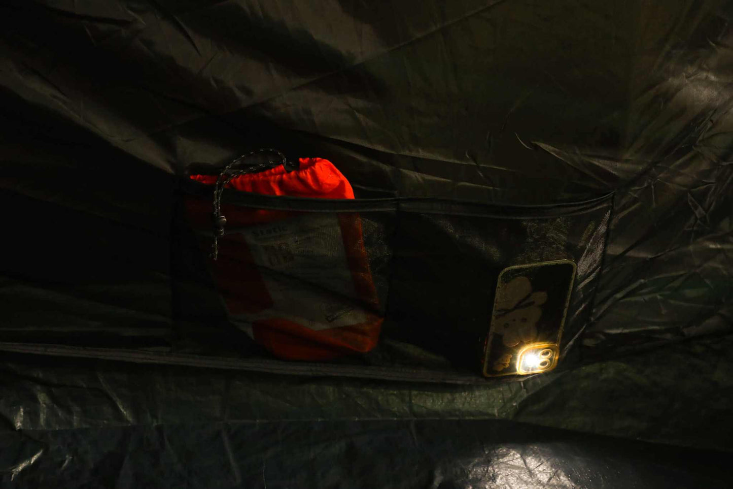 Interior view of the Morena 4.0 blackout tent, showcasing storage pocket with gear and interior lighting.