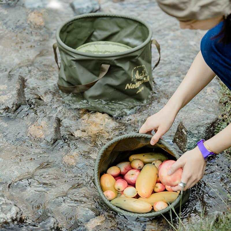 Foldbar vandtæt spand 20L fra Naturehike i brug i naturen, ideel til opbevaring i al slags vejr.