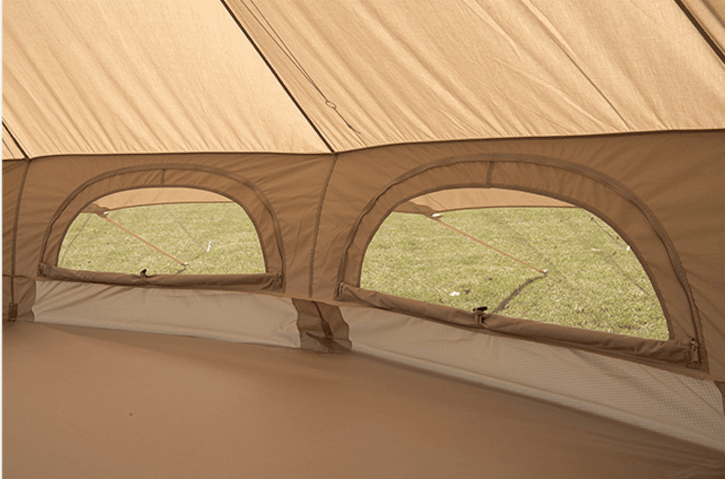 Glamping tipi tent interior with mesh windows and brown fabric.